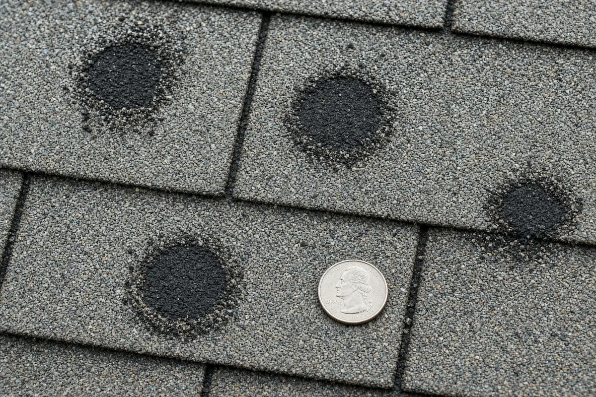 Photo: storm-damaged roofing showing broken surfaces.